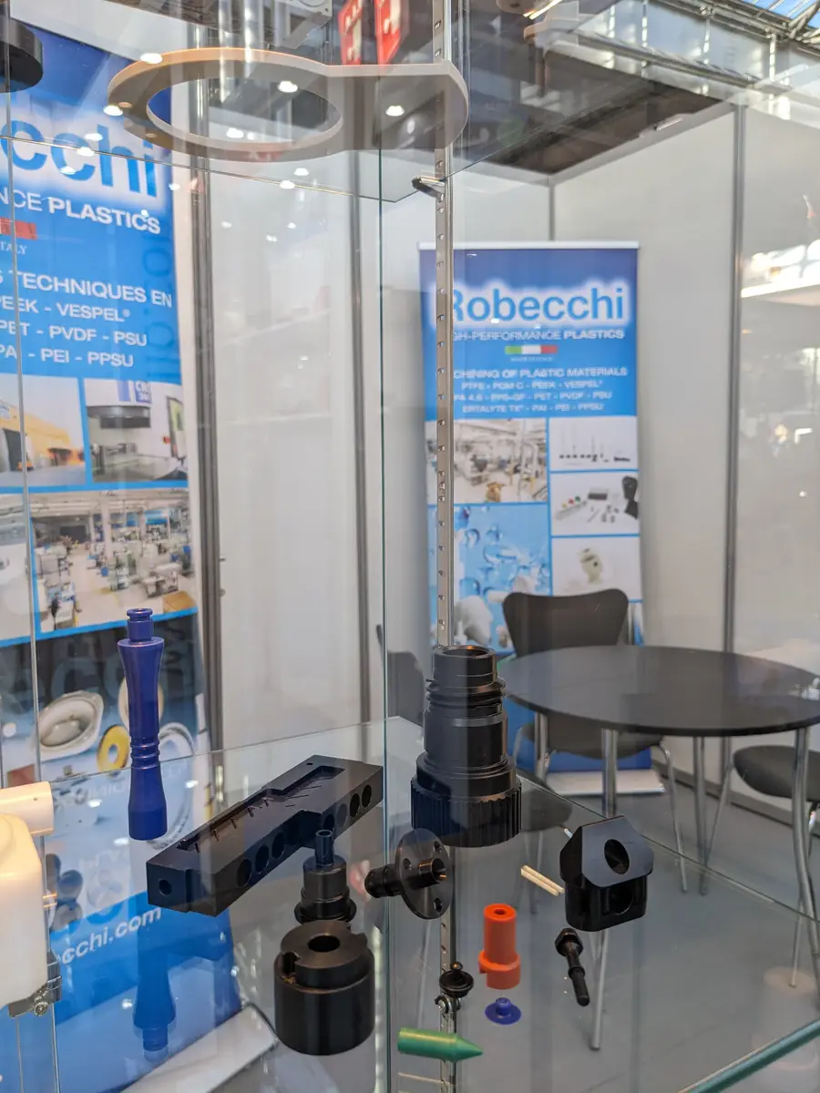 Stand di Robecchi in una fiera nel settore della lavorazione delle materie plastiche, con esposizione di componenti e polimeri plastici.